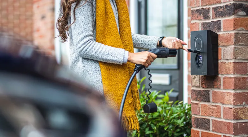 Sähköauton latausasema autotallissa, auto kytkettynä lataukseen
